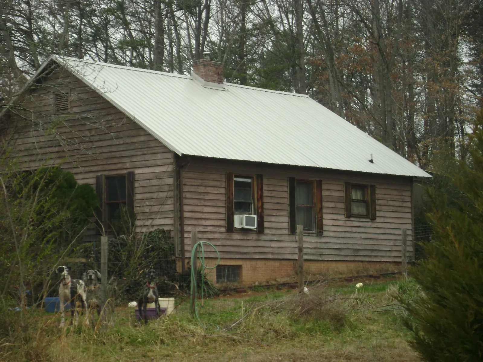 White metal roof on an old wood sided farmhouse, from a Metal Roof Installation job in Martelle